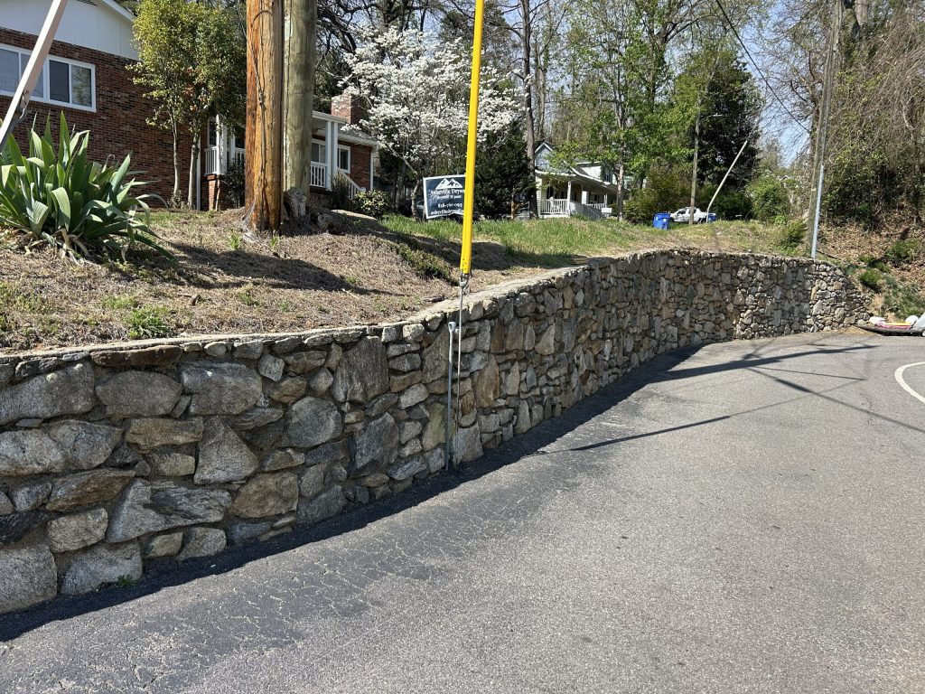 Natural stone roadside retaining wall providing structural support in Los Angeles