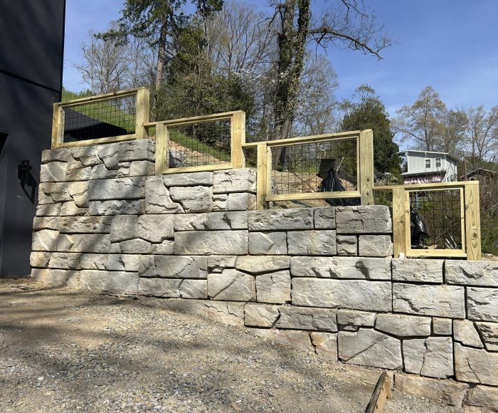 Modern block retaining wall installation designed for structural support, drainage performance, and clean landscape integration